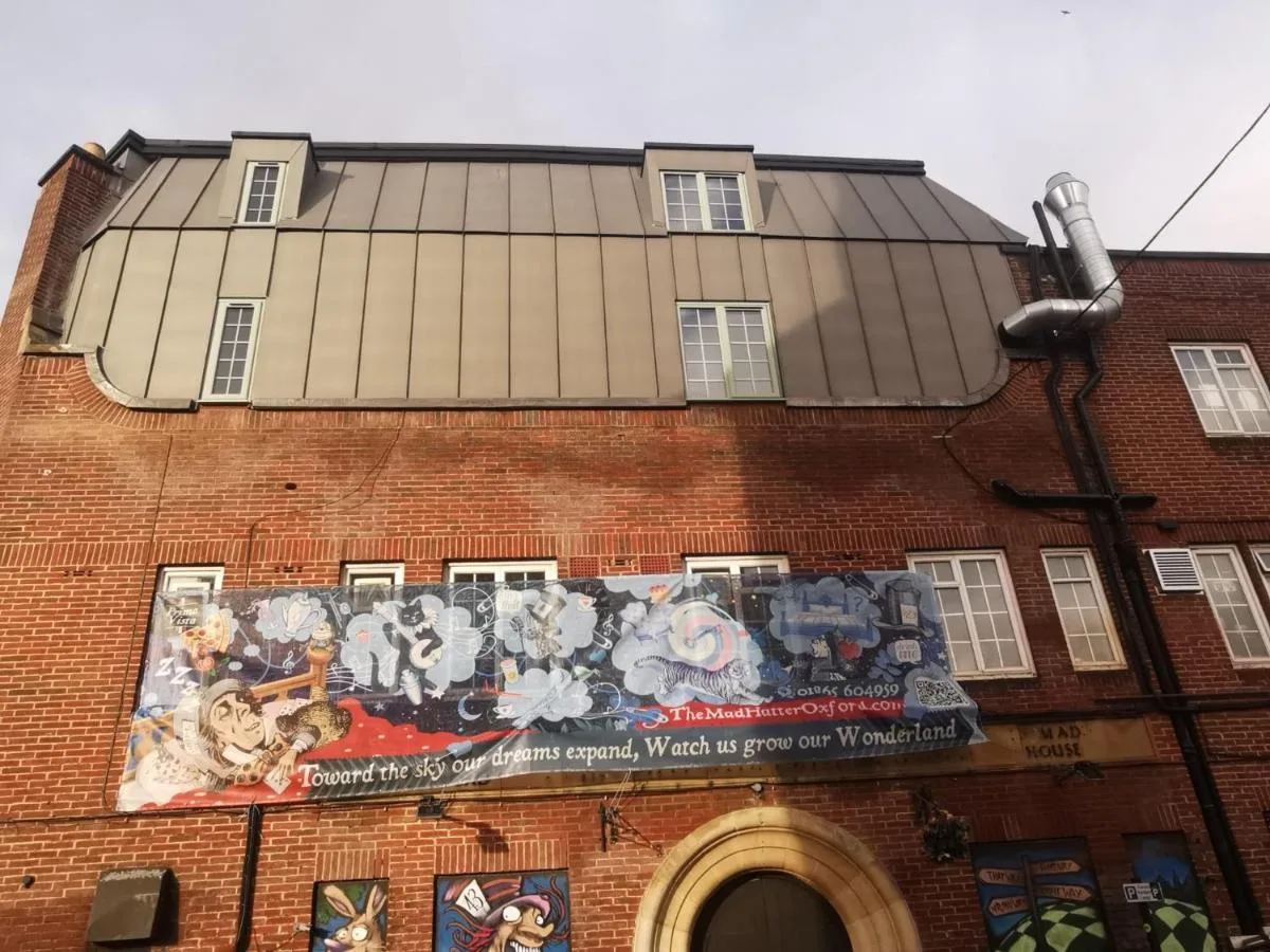 A building with a mural on the side at The Mad Hatter's Guestrooms on Iffley Road, Oxford