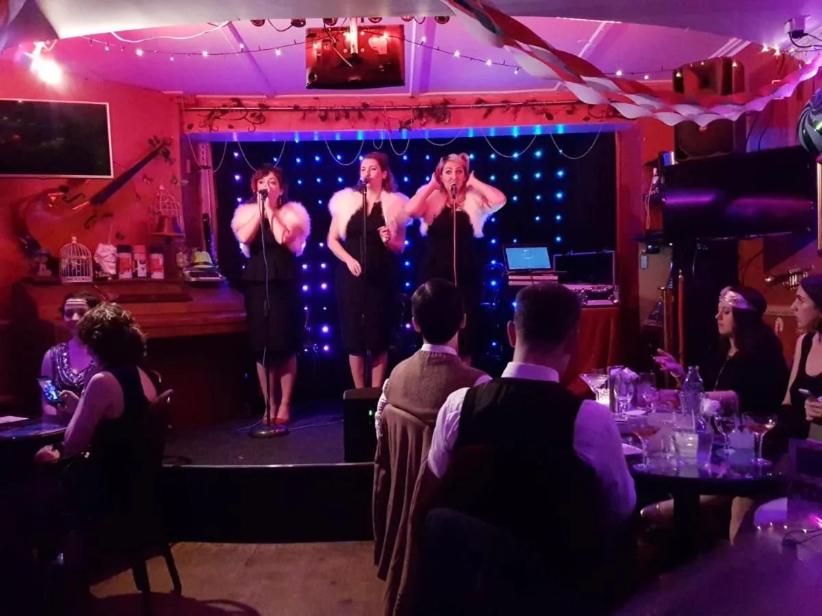 A group of men performing on stage in the bar at The Mad Hatter's Guestrooms